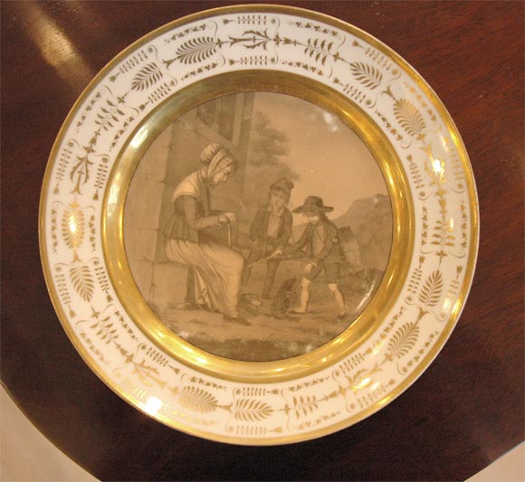 Paris porcelain display plate with detailed scene of an older lady and two young boys in French provencial clothes. Central Painting is wreathed by a gilt border in regency fashion.<br />
<br />
Red factory mark in French on back.<br />
<br